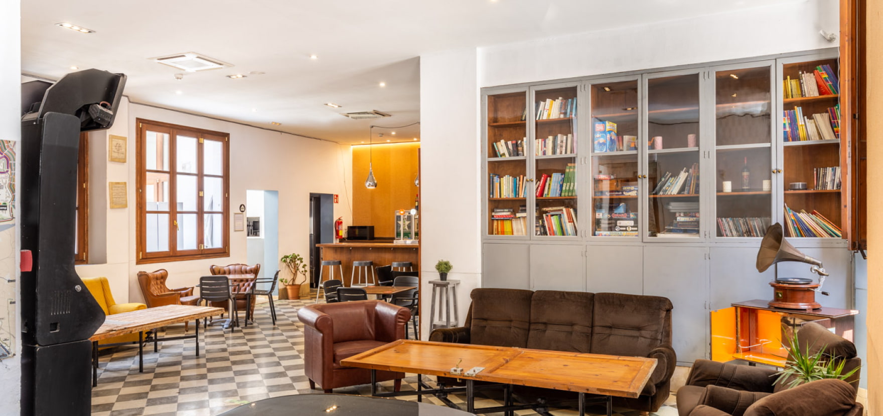 Zona con sofás, piano y biblioteca