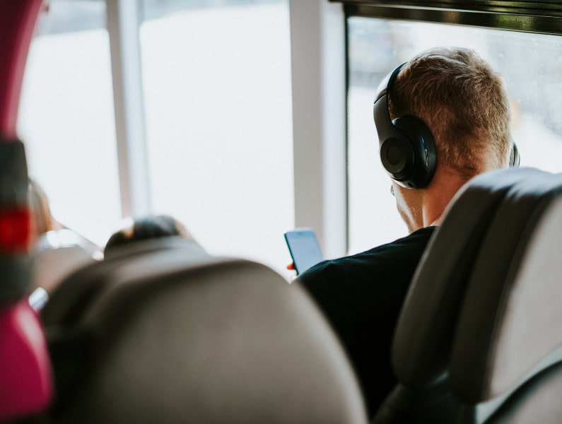Autobús Palma de Mallorca Chico de espaldas con auriculares dentro de un autobús